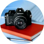 Camera op boek symboliseert het maken van employee testimonials via recruitment video en fotocontent