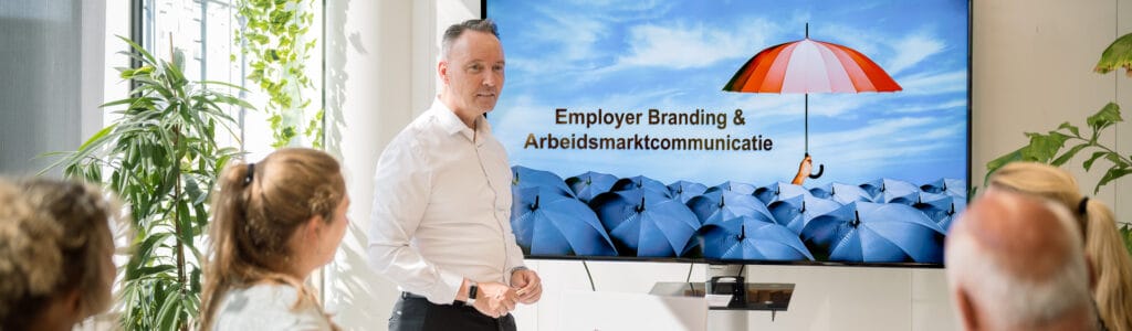 Trainer geeft uitleg over arbeidsmarktcommunicatie aan groep professionals