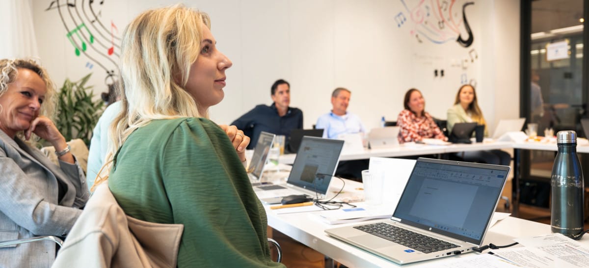 Deelnemers aan training arbeidsmarktcommunicatie werken met laptops in vergaderruimte